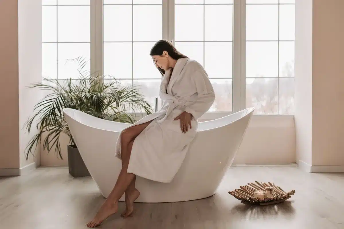 A woman relaxes in a modern bathtub, embodying tranquility and self-care, relevant to choosing a facial spa.