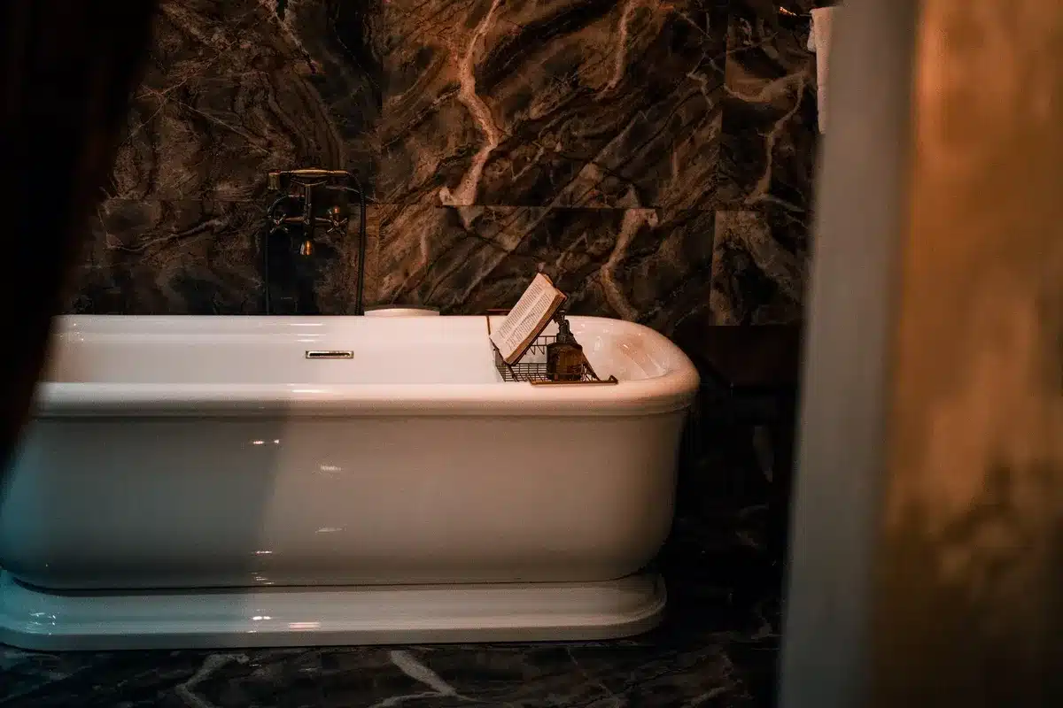 A luxurious bathroom with a white bathtub and marble walls, evoking a serene atmosphere for skincare treatments.