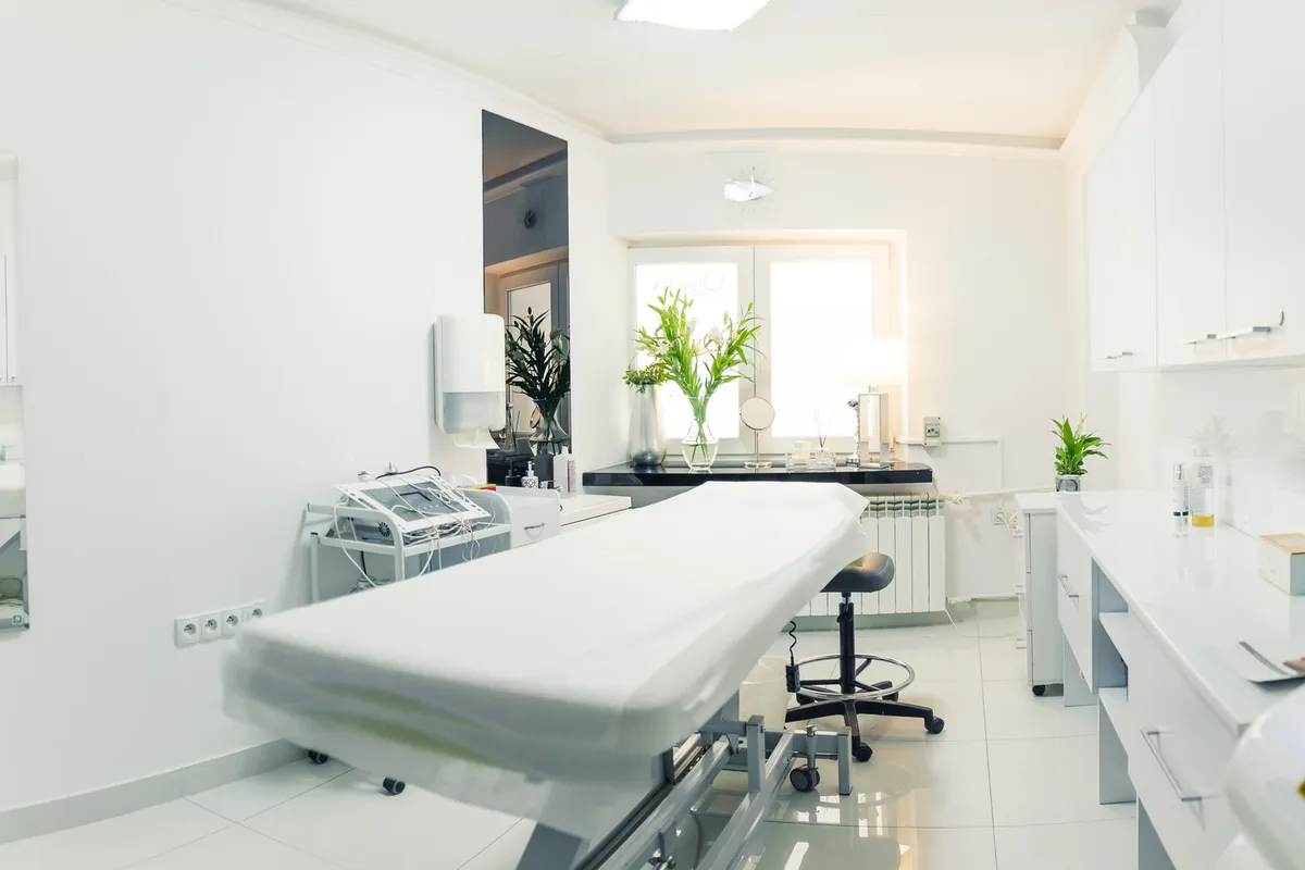 A clean and inviting spa room with a comfortable bed, ideal for facial treatments.