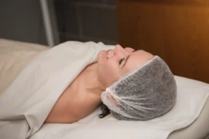 A young woman receiving a facial massage in a serene treatment room at a beauty spa.