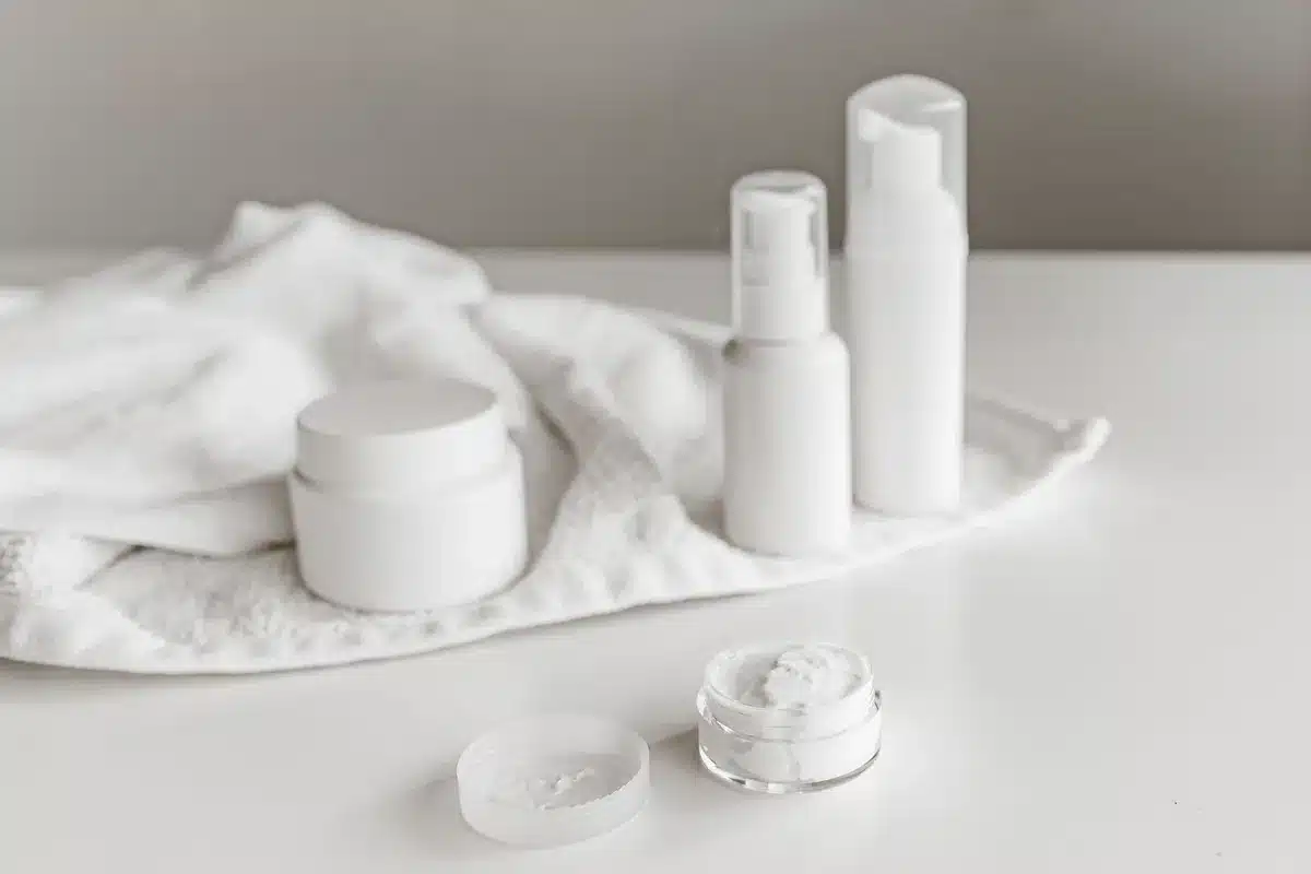 Elegant skincare products arranged on a white surface, reflecting simplicity and purity in oncology facials.
