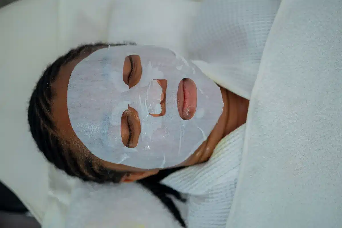 Woman relaxing with a facial mask treatment at a spa, highlighting the benefits of oncology facials.